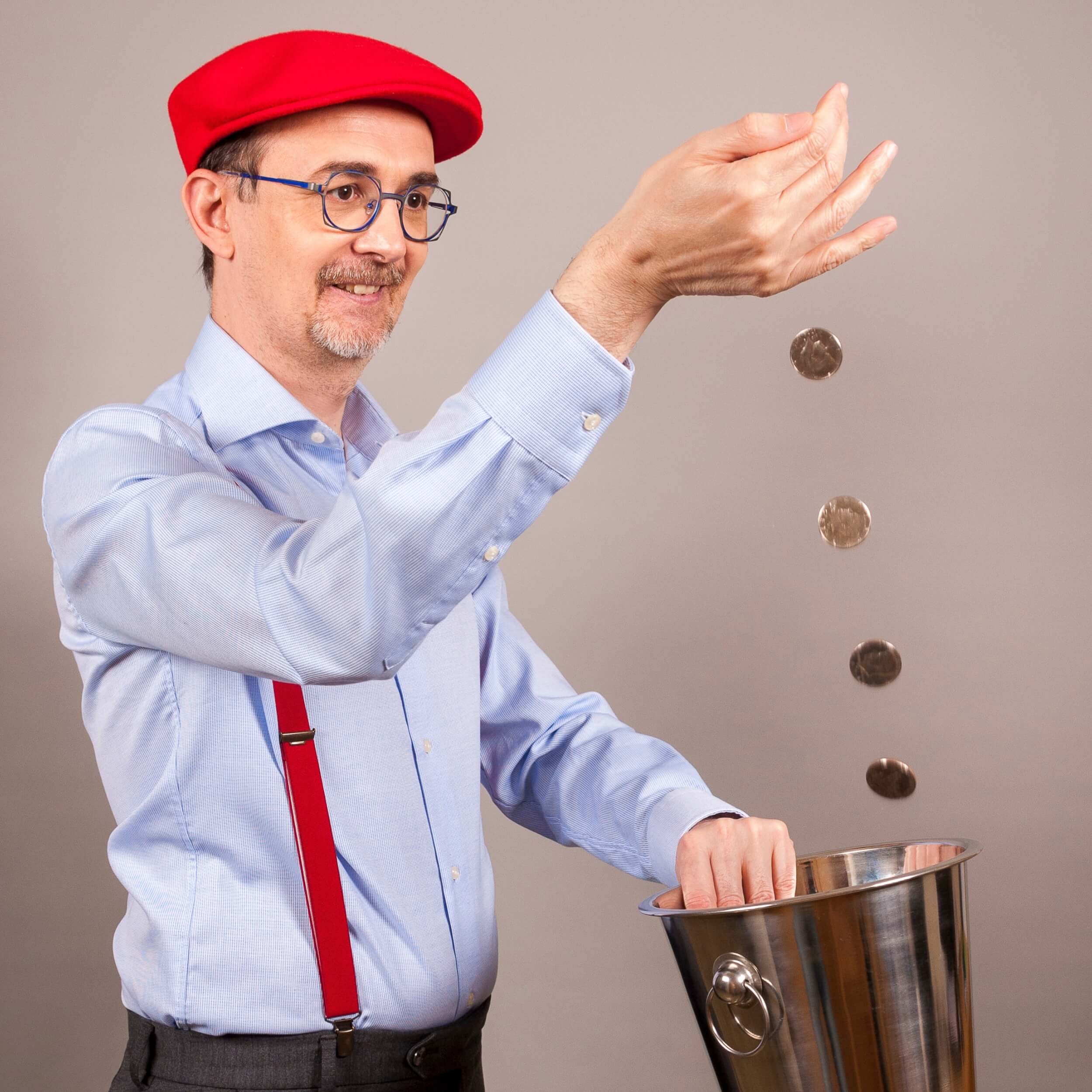 Un homme fait tomber des pièces dans un sceau. On voit les pieces tomber en rytme